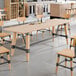 A Lancaster Table & Seating wooden trestle table base with metal accents.