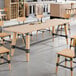 A standard height trestle table with a bleached oak finish and metal supports, designed for 30" x 96" table tops.