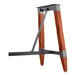 A Lancaster Table & Seating Industrial Rustic Mahogany finish trestle table base with metal legs and a wooden stand.