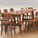 A Lancaster Table & Seating standard height trestle table base for a table with glasses and chairs.