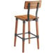 A Lancaster Table & Seating Rustic Industrial bar stool with a wooden seat and metal frame.