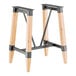 Lancaster Table & Seating industrial bleached oak trestle table base with wooden legs and a black metal frame.