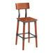 A Lancaster Table & Seating wooden bar stool with a metal frame and a rustic mahogany finish.