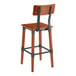 A Lancaster Table & Seating wooden bar stool with a metal frame and a black back.