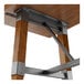 A wooden table with a rustic walnut finish and metal trestle base supports.