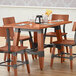 A Lancaster Table & Seating solid wood table with a brown live edge surface and trestle base.