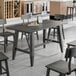 A Lancaster Table & Seating live edge wood table with chairs and a plate on it.
