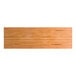A rectangular solid wood table top with a honey maple finish and live edge design.