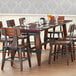 A Lancaster Table & Seating solid wood dining table with wine glasses on it.