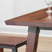 A Lancaster Table & Seating live edge wood table with a glass on it.