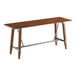 A rectangular bar height table with a solid wood live edge top in a rustic walnut finish and a metal trestle base.