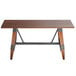 A Lancaster Table & Seating solid wood table with metal legs.