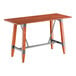 A rectangular bar height table with a solid wood live edge top in a rustic mahogany finish and a metal trestle base.