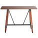 A Lancaster Table & Seating solid wood live edge bar height table with metal legs.