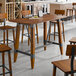 A Lancaster Table & Seating live edge wooden table with a trestle base.