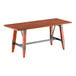 A Lancaster Table & Seating wooden table with metal trestle legs.