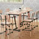 A Lancaster Table & Seating wooden bar height trestle table with an antique white wash finish.