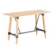 A Lancaster Table & Seating bar height wooden table with a live edge top and trestle base.