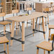 A Lancaster Table & Seating solid wood live edge bar height table with a plate on it.