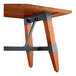 A Lancaster Table & Seating wooden table with a trestle base and metal legs.