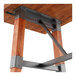 A wooden trestle base table with a rustic mahogany finish and metal supports.