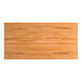A rectangular solid wood table top with a honey maple finish and a live edge design.