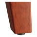 The trestle base of a Lancaster Table & Seating bar height table with a wood surface.