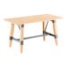 A rectangular solid wood table with a bleached oak finish and an industrial-style trestle base featuring metal supports.