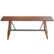 A Lancaster Table & Seating wooden table with metal legs.