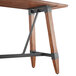 A Lancaster Table & Seating wooden bar height trestle table with metal legs.