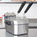 A Waring stainless steel countertop deep fryer on a counter.