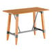 A Lancaster Table & Seating bar height table with a wooden live edge top and trestle base.