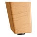 A close up of a wood block on a Lancaster Table & Seating trestle base.