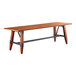 A Lancaster Table & Seating wooden table with metal trestle legs.