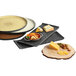 A Libbey faux slate porcelain tray with 3 wells holding a bowl of food, cheese, and grilled fruit.