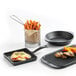 A Libbey stainless steel fry presentation basket with French fries inside.