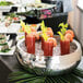 A Libbey Sonoran stainless steel bowl filled with shrimp cocktails on a table with other food.