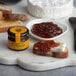 A piece of bread with Dalmatia Original Fig Spread on top sitting on a marble board.