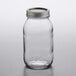 A Ball clear glass quart jar with a silver lid on a table.