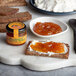 A plate with bread, cheese, and Dalmatia Tangerine Spread on it.