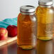 Two Ball wide mouth glass canning jars with apples and liquid.