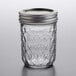 A Ball glass canning jar with a silver metal lid on a table.