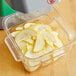 A container of sliced yellow squash in a food processor with a AvaMix 1/8" Slicing Disc.