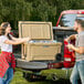 A man and woman loading CaterGator coolers into a truck.