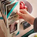 A hand holding a package of Piller's Black Kassel salami whips.