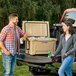 A man and woman standing next to a CaterGator outdoor cooler with the lid open.