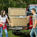 A man and woman standing next to a CaterGator outdoor cooler.