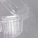 A close-up of a Genpak clear plastic deli container with a high dome lid.