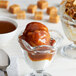 A glass cup of I. Rice salted caramel sauce on a bowl of ice cream.