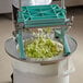 a hand pouring lettuce into a container